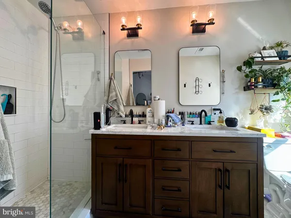 a bathroom with double vanity and a mirror