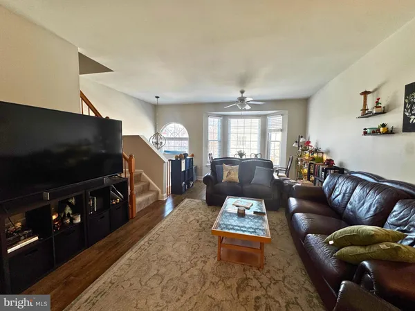 a living room with furniture a flat screen tv and a window
