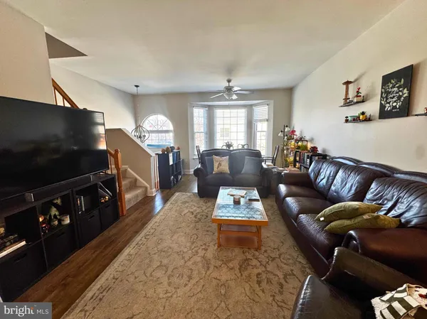 a living room with furniture a flat screen tv and a window