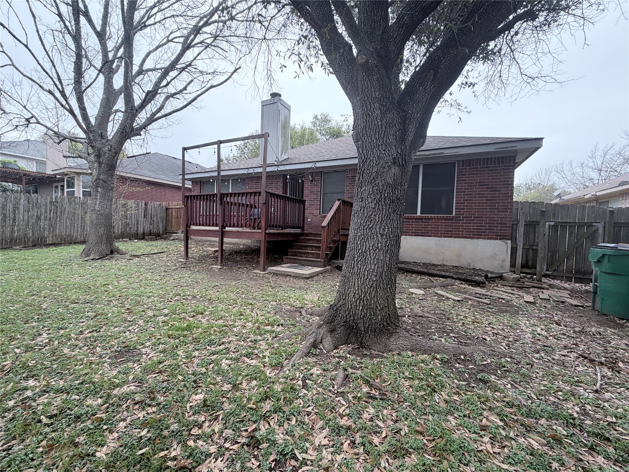 20809 Pacers Gait Lane Pflugerville, TX 78660 - Photo 17 of 23 Rear view of property featuring a fenced backyard, a wooden deck, brick siding, a chimney, and a gate