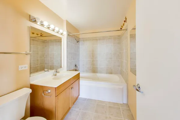 a bathroom with a tub sink and mirror