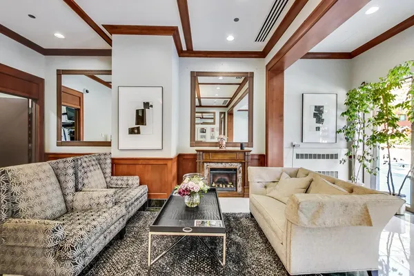 a living room with furniture fireplace and a large window