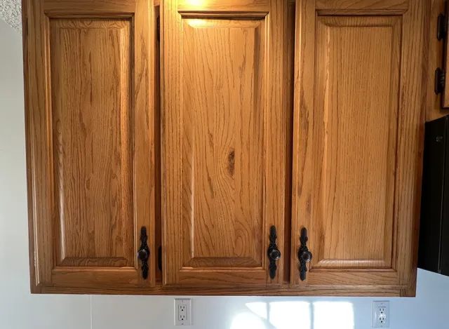 an empty room with windows fireplace and wooden floor