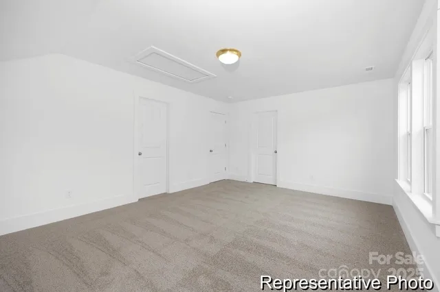 an empty room with a kitchen space and a window