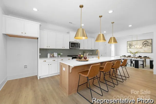 a kitchen with stainless steel appliances kitchen island granite countertop a stove a sink a dining table and chairs
