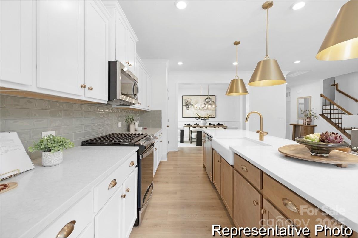 116 Soft Breeze Bend, Unit 163B Locust, NC 28097 - Photo 4 of 30 a kitchen with sink a stove and cabinets