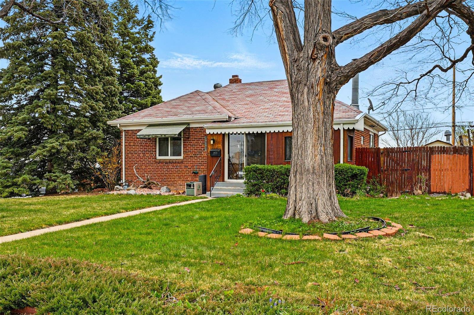 a front view of a house with a yard and trees