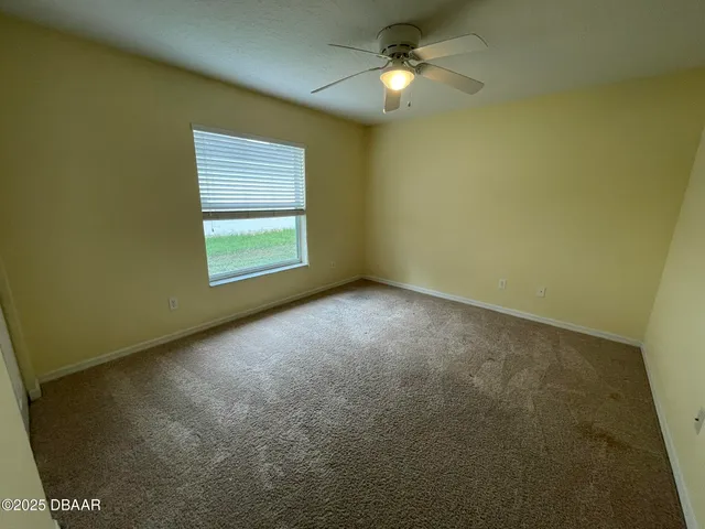 an empty room with a window and a fan