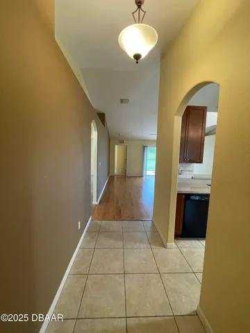 a view of a hallway with wooden floor and a bathroom