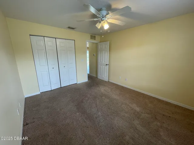 an empty room with a ceiling fan and a window