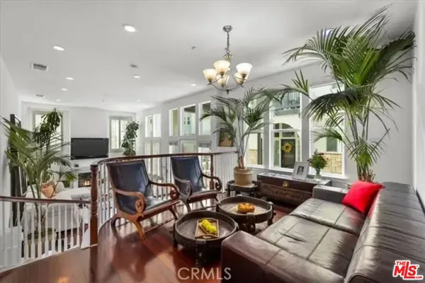 a living room with furniture a chandelier and kitchen view