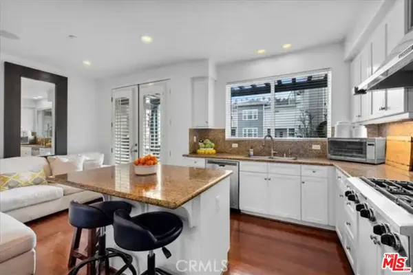 a kitchen with stainless steel appliances granite countertop a stove a sink and a refrigerator