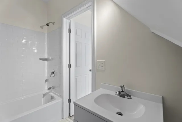 a bathroom with a bathtub shower sink and toilet