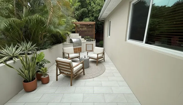 a view of a patio with chairs and potted plants