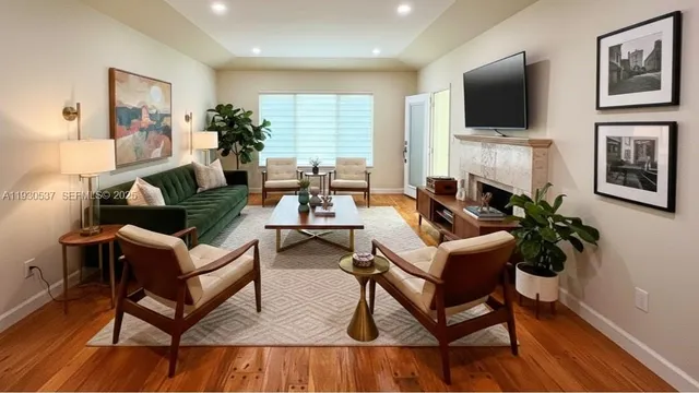 a living room with furniture a flat screen tv and a fireplace