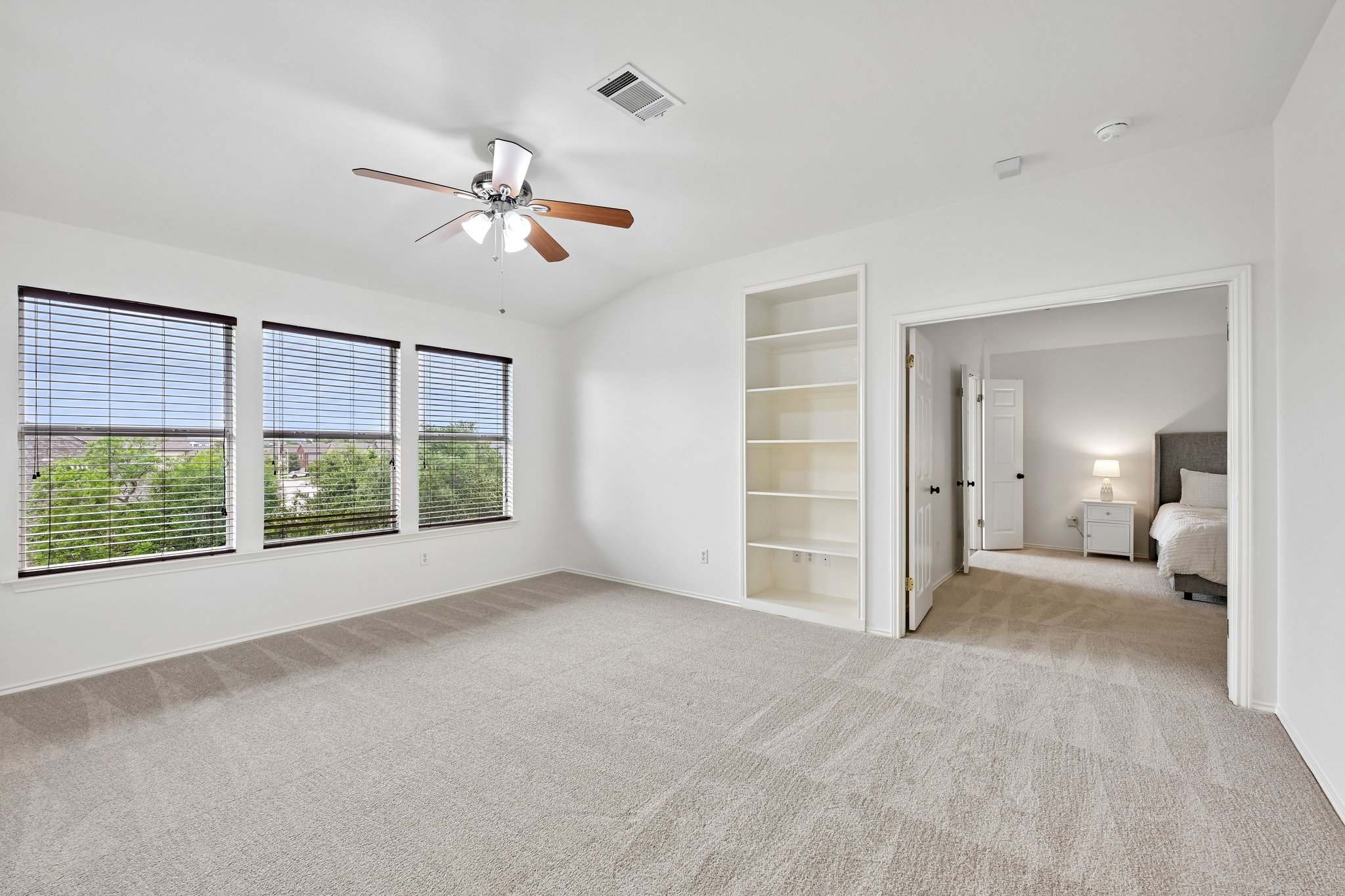 4100 Mocha Trail Austin, TX 78728 - Photo 11 of 33 Well-lit interior space with plush carpeting, built-in shelving, and multiple windows.