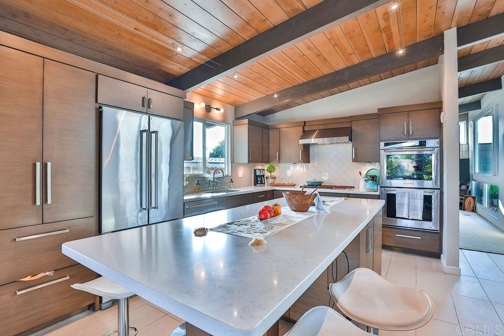 a living room with stainless steel appliances granite countertop table chairs and a refrigerator
