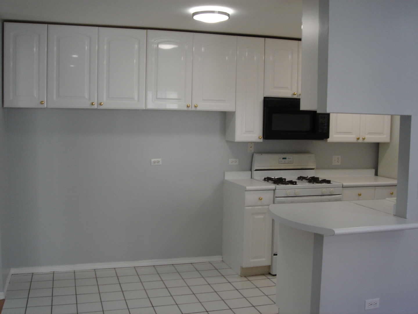 5420 North Sheridan Road, Unit 408 Chicago, IL 60640 - Photo 13 of 17 a kitchen with a stove a white cabinet and a sink