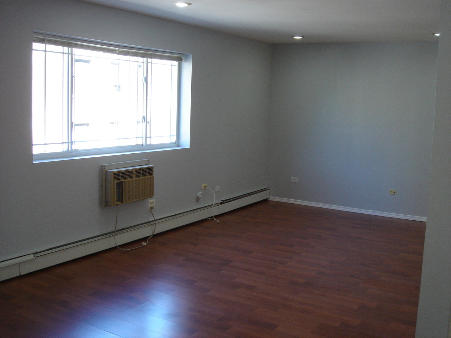 5420 North Sheridan Road, Unit 408 Chicago, IL 60640 - Photo 10 of 17 an empty room with wooden floor and windows