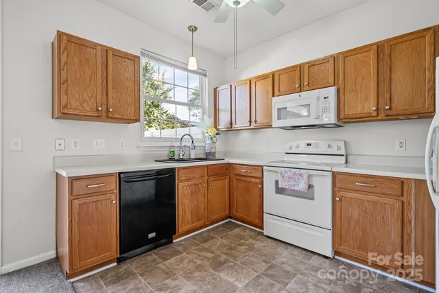 a kitchen with stainless steel appliances granite countertop a sink stove and cabinets