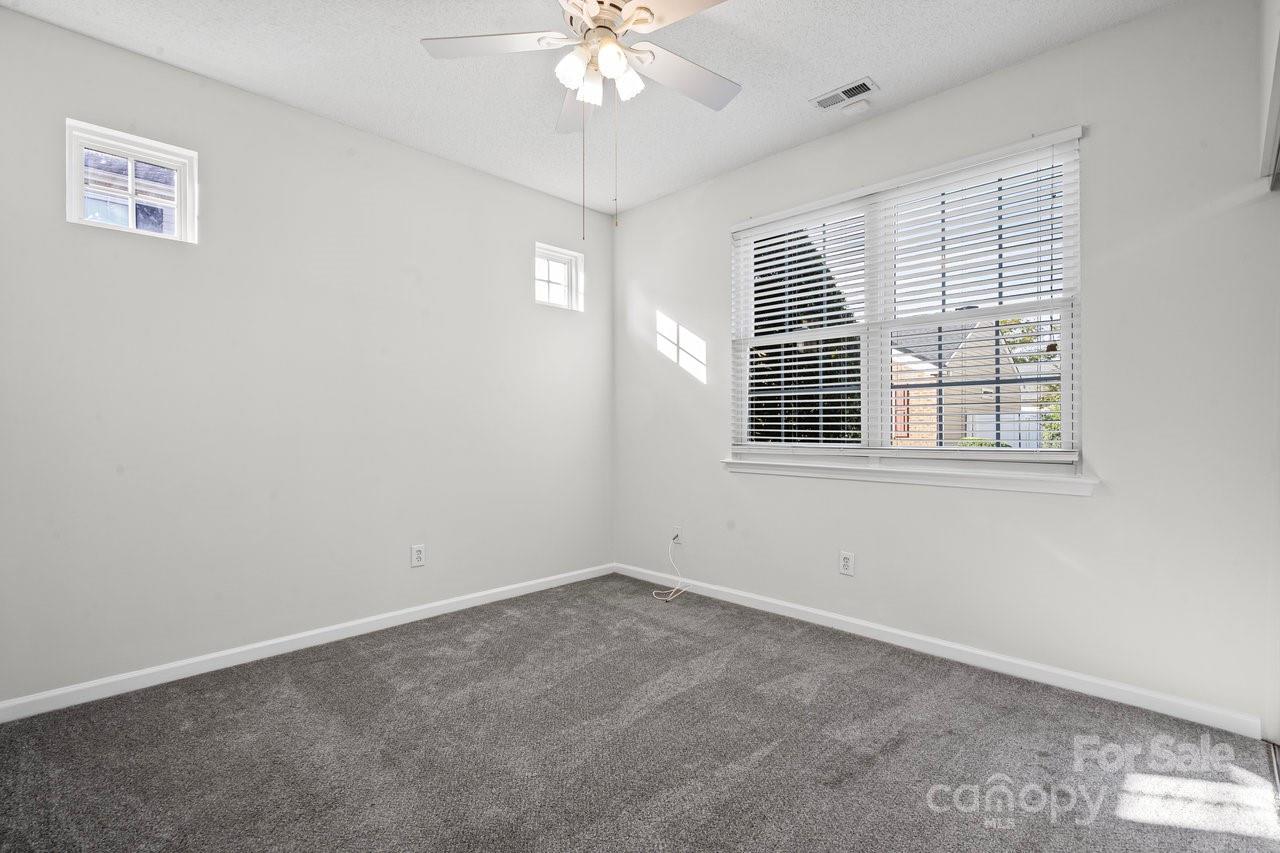 8663 Meadowmont View Drive Charlotte, NC 28269 - Photo 17 of 30 an empty room with windows and fan