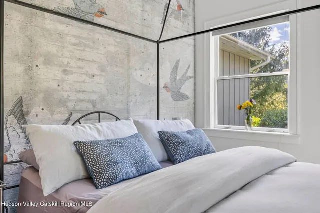 a bedroom with a bed and a painting on the wall