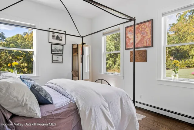 a bedroom with a bed and large windows