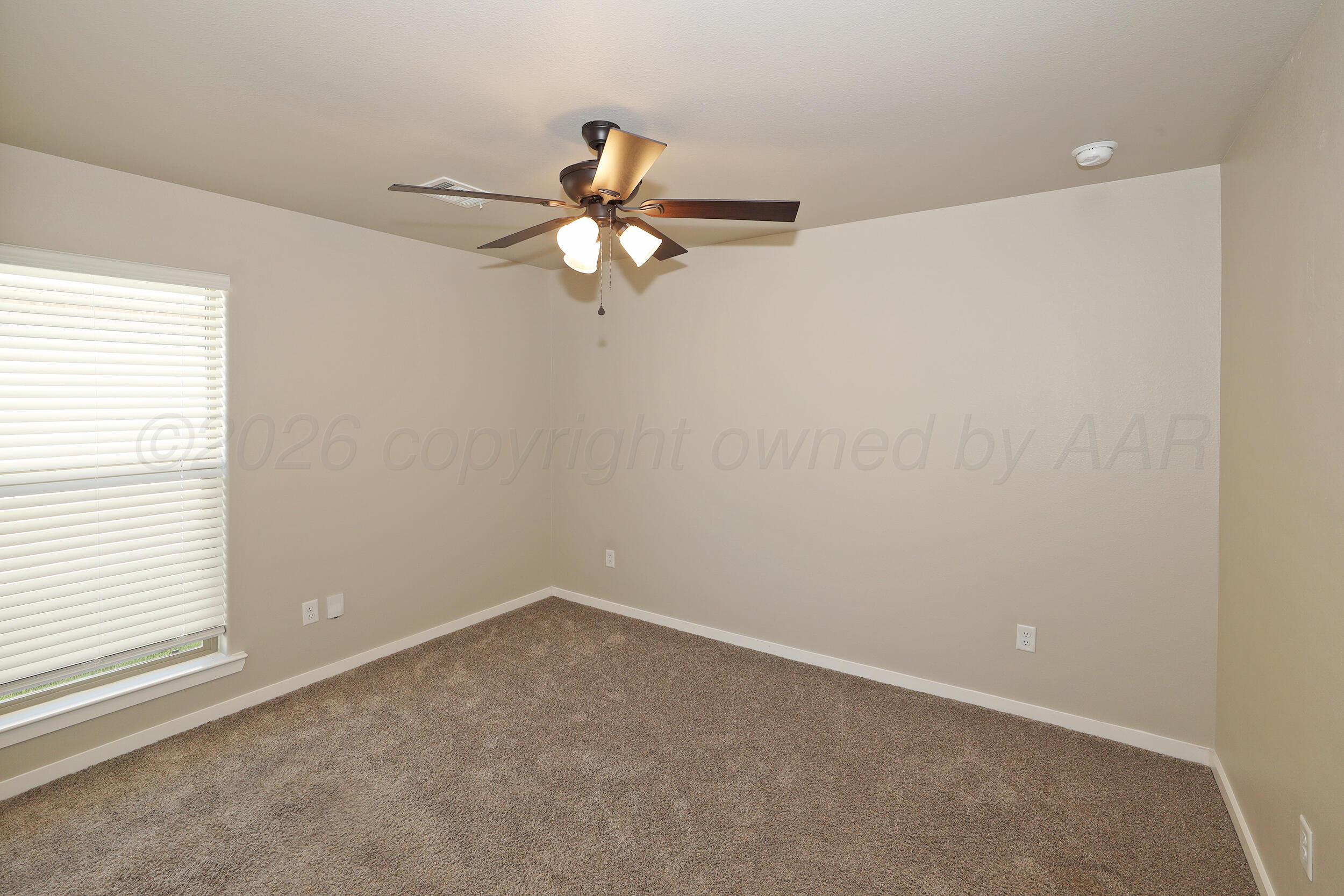7205 Athens Street Amarillo, TX 79118 - Photo 14 of 25 an empty room with a window and a fan