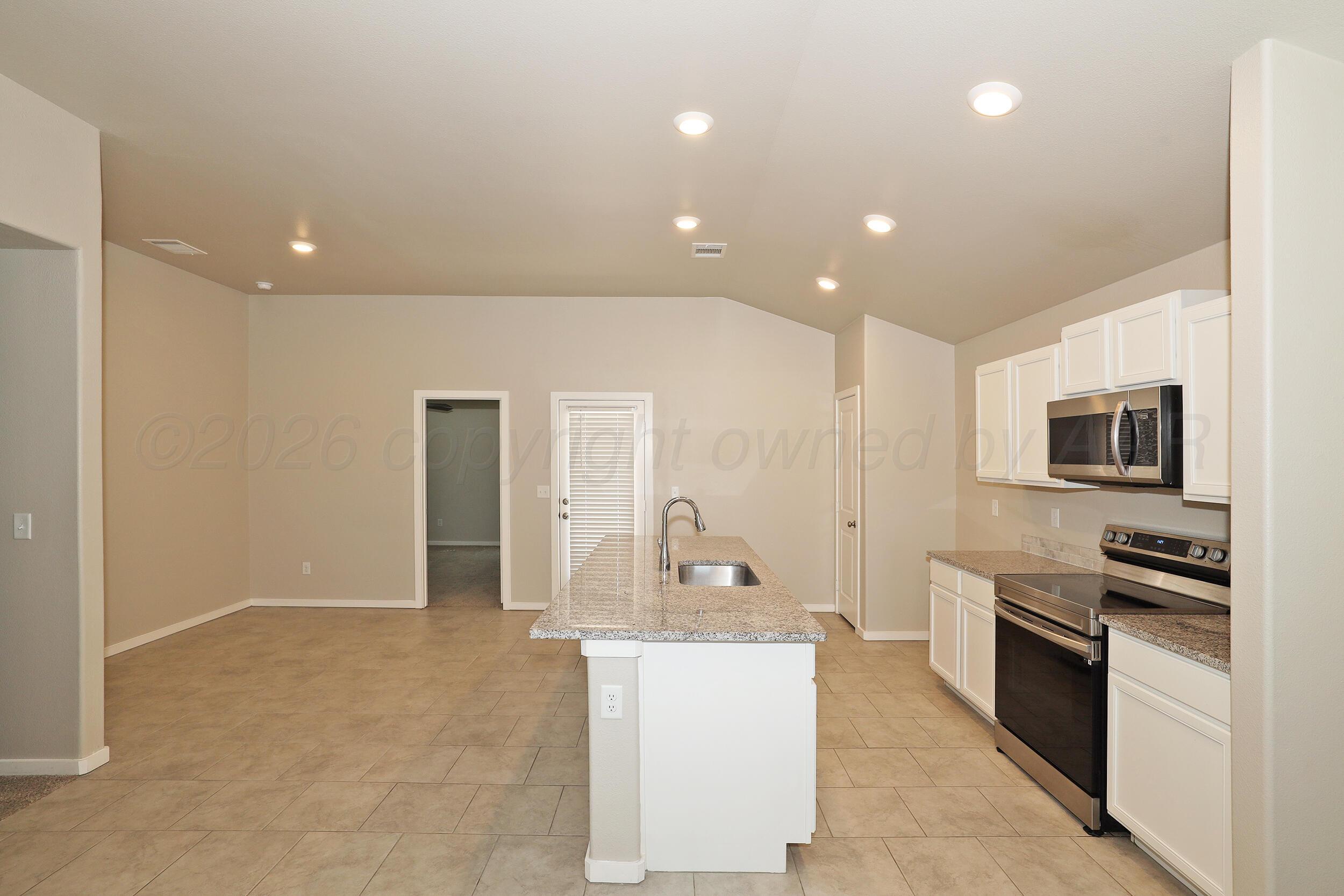 7205 Athens Street Amarillo, TX 79118 - Photo 6 of 25 a large kitchen with kitchen island a sink stainless steel appliances and cabinets