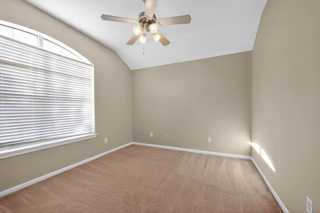 an empty room with a window and a fan