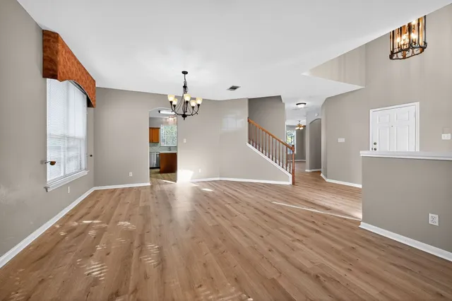 a view of a livingroom with wooden floor and staircase