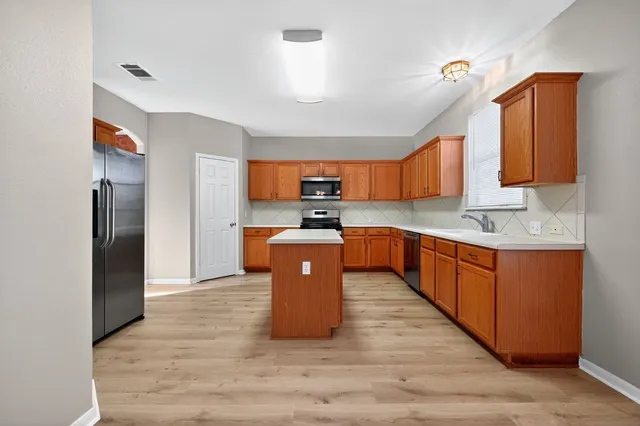 a large kitchen with stainless steel appliances granite countertop a stove a sink dishwasher a refrigerator and a oven