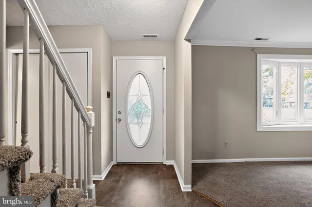 a view of a hallway with wooden floor and windows