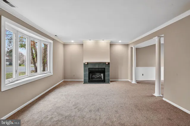 a view of an empty room with a fireplace and a window