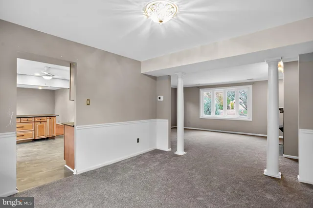 a view of an empty room with window and cabinet