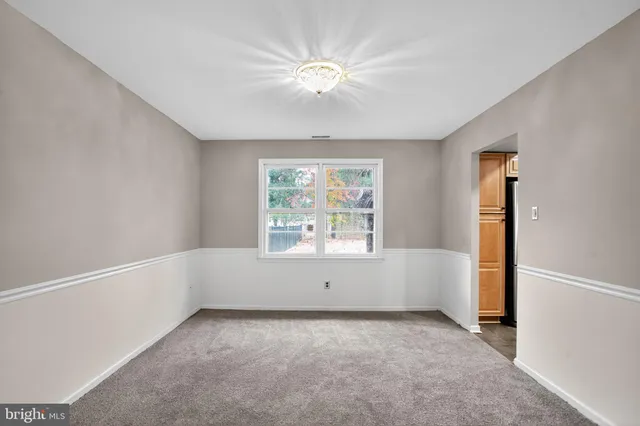 an empty room with a window and a ceiling fan