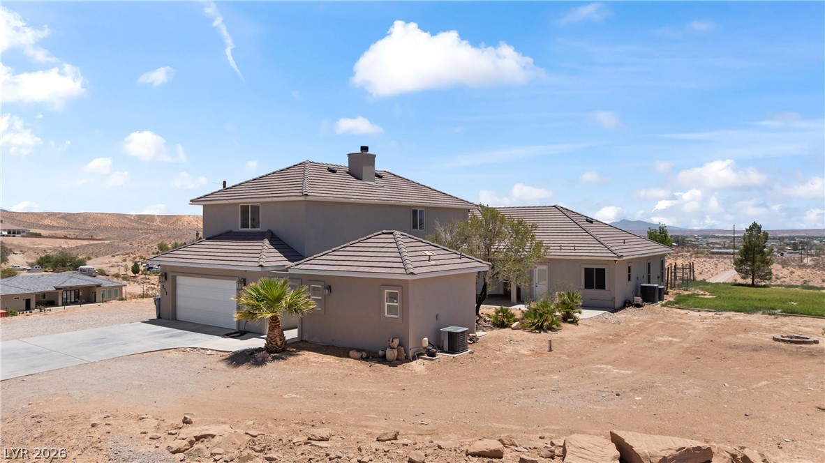 575 Gann Avenue Logandale, NV 89021 - Photo 63 of 75 A spacious desert dwelling with ample parking and a detached garage, offering sweeping landscape views.