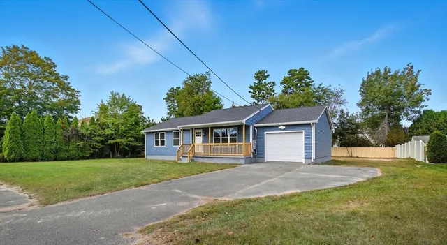 a front view of a house with a yard and trees