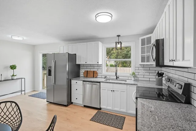 a kitchen with stainless steel appliances granite countertop a refrigerator sink and stove