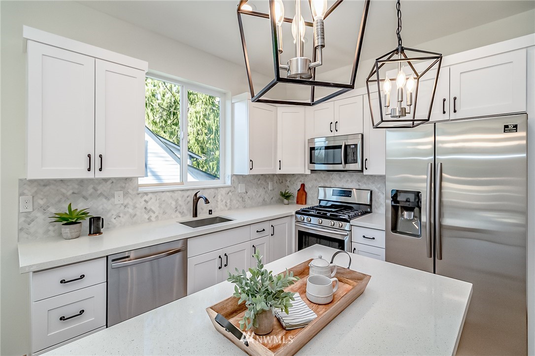 2624 Callow Road, Unit B Lake Stevens, WA 98258 - Photo 13 of 37 a kitchen with stainless steel appliances granite countertop a refrigerator a stove a sink dishwasher and white cabinets with wooden floor