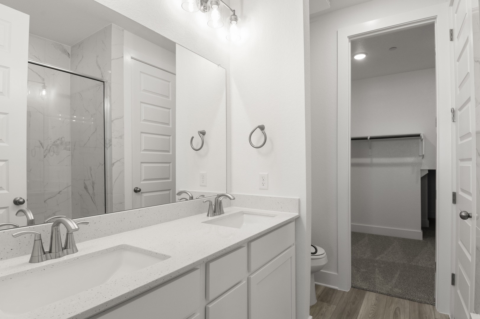 18909 Schultz Lane, Unit 1002 Round Rock, TX 78664 - Photo 20 of 24 Bathroom with a marble finish shower, double vanity, light wood-type flooring, and a walk in closet