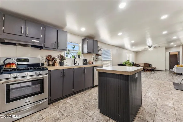 a kitchen with stainless steel appliances granite countertop a sink stove and refrigerator