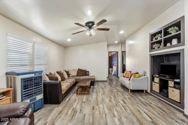 a living room with furniture kitchen view and a chandelier