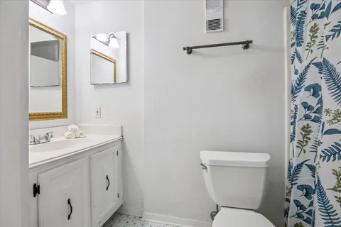 a bathroom with a toilet sink and mirror