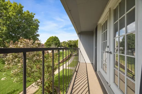 a view of balcony with wooden floor and fence
