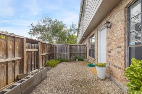 a view of a backyard with plants and wooden fence