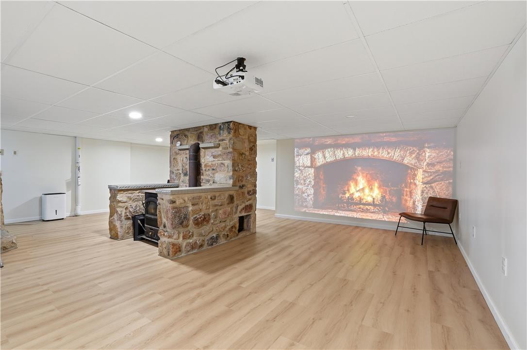 2918 Keystone Street Bethlehem, PA 18020 - Photo 26 of 54 A stone fireplace anchors this spacious basement, offering a cozy retreat with ample space for relaxation or entertainment.