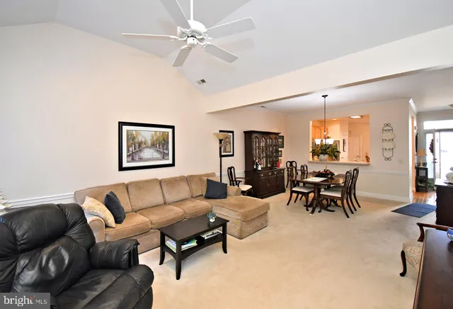 a living room with furniture a clock on wall and a window