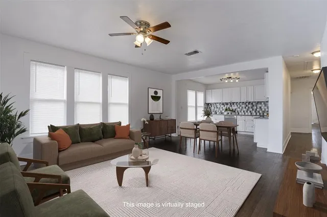 a living room with furniture wooden floor and a large window