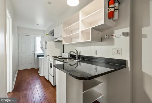 a kitchen with stainless steel appliances granite countertop a sink dishwasher and a stove with wooden floor